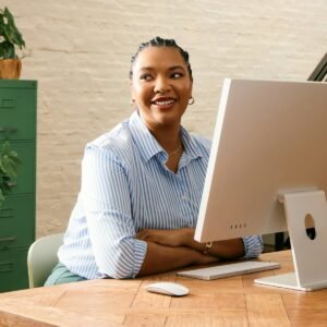 Coaching client smiling at computer | Coaching vs Consulting vs Hybrid Approach